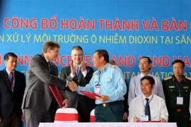 Đại diện USAID (trái) trao thỏa thuận bàn giao diện tích đất qua xử lý cho Quân chủng Phòng không-Không quân. (Ảnh: Nguyễn Sơn/TTXVN)