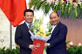 Thủ tướng Nguyễn Xuân Phúc trao Quyết định bổ nhiệm và tặng hoa cho ông Nguyễn Mạnh Hùng giữ chức Bộ trưởng Bộ Thông tin và Truyền thông nhiệm kỳ 2016-2021. (Ảnh: Thống Nhất/TTXVN)