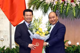 Thủ tướng Nguyễn Xuân Phúc trao Quyết định bổ nhiệm và tặng hoa cho ông Nguyễn Mạnh Hùng giữ chức Bộ trưởng Bộ Thông tin và Truyền thông nhiệm kỳ 2016-2021. (Ảnh: Thống Nhất/TTXVN)