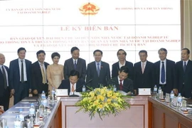 Ông Nguyễn Hoàng Anh, Chủ tịch Ủy ban Quản lý vốn Nhà nước tại doanh nghiệp (bên trái) và Bộ trưởng Bộ Thông tin và Truyền thông Nguyễn Mạnh Hùng ký Biên bàn bàn giao. (Ảnh: Doãn Tấn/TTXVN)