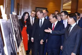 Thủ tướng Liên bang Nga Dmitry Medvedev và Thủ tướng Nguyễn Xuân Phúc tham quan Trưng bày ảnh Việt-Nga: Quan hệ hữu nghị truyền thống và hợp tác toàn diện. (Ảnh: Thống Nhất/TTXVN)
