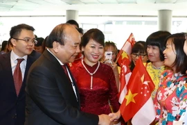 Cán bộ, nhân viên Đại sứ quán Việt Nam đón Thủ tướng Nguyễn Xuân Phúc và Phu nhân tại sân bay quốc tế Changi. (Ảnh: Thống Nhất/TTXVN)