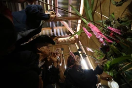 Sau khi cúng mời tổ tiên, các con cháu uống rượu cần mời ông bà về chung vui với dòng họ. (Ảnh: Pha Tuấn Anh/TTXVN)