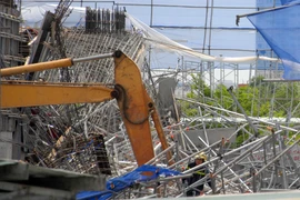 Lực lượng cứu hộ, cứu nạn đang tích cực tìm kiếm nạn nhân thứ 3 bị chôn vùi trong đống đổ nát. (Ảnh: Mạnh Linh/TTXVN)