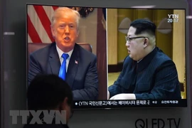 Người dân theo dõi qua truyền hình hình ảnh Tổng thống Mỹ Donald Trump (trái) và Nhà lãnh đạo Triều Tiên Kim Jong-un ngày 24/5 vừa qua. (Ảnh: AFP/TTXVN)