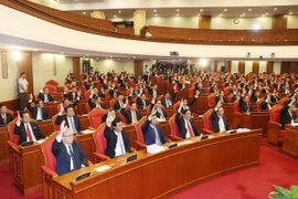 Các đồng chí lãnh đạo Đảng, Nhà nước và các đại biểu biểu quyết thông qua Nghị quyết Hội nghị lần thứ bảy. (Ảnh: Trí Dũng/TTXVN)