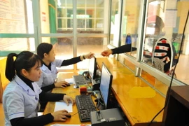 Thực hiện chi trả bảo hiểm y tế qua phần mềm bằng máy tính tại Bệnh viện Sản Nhi. (Ảnh: Minh Đức/TTXVN)