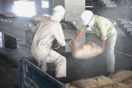 Bốc xếp ximăng đi tiêu thụ. (Ảnh: Minh Đông/TTXVN)