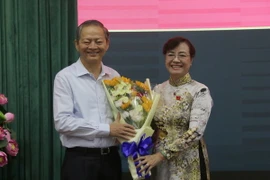 Chủ tịch HĐND Thành phố Hồ Chí Minh Nguyễn Thị Quyết Tâm tặng hoa ông Lê Văn Khoa. (Ảnh: Tiến Lực/TTXVN)