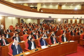 Các đồng chí lãnh đạo Đảng, Nhà nước và các đại biểu biểu quyết thông qua Nghị quyết Hội nghị lần thứ bảy. (Ảnh: Trí Dũng/TTXVN)