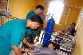 Lực lượng quân y đảo Phan Vinh cấp cứu cho ngư dân. (Ảnh: TTXVN phát)