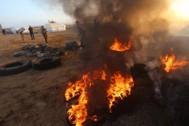 Người Palestine đốt lốp xe trong cuộc biểu tình tại khu vực biên giới Dải Gaza với Israel. (Nguồn: THX/TTXVN.)