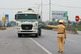 Kiểm tra xe quá khổ, quá tải lưu thông trên đường. (Ảnh: Doãn Tấn/TTXVN)