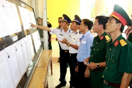 Cử tri thuộc các đơn vị lực lượng vũ trang huyện đảo Lý Sơn, Quảng Ngãi, tìm hiểu tiểu sử các ứng cử viên trước khi tiến hành bỏ phiếu. (Ảnh: Vĩnh Trọng/TTXVN)