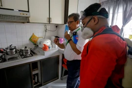 Nhân viên Công ty NEA hướng dẫn người dân diệt muỗi trong nhà ở quận Bedok North ngày 1/9. (Nguồn: EPA/ TTXVN)