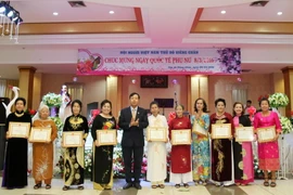 Công sứ Hoàng Xuân Hải và các cá nhân có thành tích xuất sắc trong sự phát triển của cộng đồng. (Ảnh: Phạm Kiên/Vietnam+)