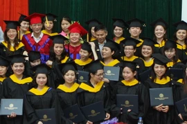 Các tân thạc sỹ Trường Đại học Ngoại ngữ - Đại học Quốc gia Hà Nội nhận bằng tốt nghiệp. (Ảnh: Bích Ngọc/TTXVN)