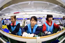 Công nhân làm việc tại nhà máy ở Rushan, tỉnh Sơn Đông, miền đông Trung Quốc. (Nguồn: THX/TTXVN)