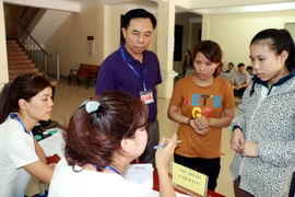 Thí sinh nghe tư vấn của cán bộ phòng đào tạo trường Đại học Y khoa Vinh. (Ảnh: Bích Huệ/TTXVN)