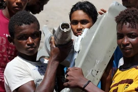 Trẻ em Yemen tìm thấy mảnh vỡ được cho là của máy bay chiến đấu của liên quân Arab gặp nạn ở Aden. (Nguồn: AFP/TTXVN)