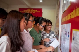 Sinh viên xem danh sách các ứng cử viên trước khi bầu cử. (Ảnh: Trọng Đạt/TTXVN)