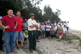 Người thân, thầy cô, bạn bè và người dân tại hiện trường vụ đuối nước thương tâm. (Ảnh: Văn Đạt/TTXVN)