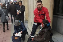 Nhân viên an ninh hỗ trợ người bị thương sau vụ nổ ở ga tàu điện ngầm Maalbeek ở Brussels ngày 22/3. (Nguồn: AFP/TTXVN)
