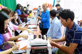 Người dân Hà Tĩnh làm thủ tục nhận tiền bồi thường. (Ảnh: Công Tường/TTXVN)
