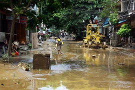 Máy xúc dọn dẹp hậu quả cơn bão số 3 trên đường Thanh Niên, thành phố Yên Bái. (Ảnh: Thế Duyệt/TTXVN)