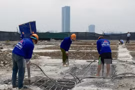 Công nhân Công ty Cổ phần Tập đoàn Phương Bắc dùng máy khoan phá dỡ phần trần bê tông. (Ảnh: Minh Nghĩa/TTXVN)
