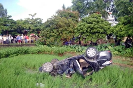 Chiếc ôtô bị tàu hỏa đâm văng xa 10m và rơi xuống ruộng lúa. (Ảnh: Mạnh Tú/TTXVN)