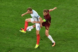 Tiền đạo Harry Kane (trái) đội tuyển Anh tranh bóng quyết liệt với hậu vệ Vasily Berezutskiy (đội tuyển Nga). (Nguồn: AFP/TTXVN)