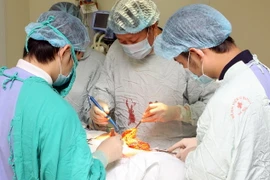Các bác sỹ Bệnh viện Ung Bướu Hà Nội thực hiện một ca phẫu thuật. (Ảnh: Dương Ngọc/TTXVN)