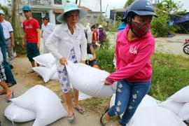 Ngư dân xã Phú Thuận, huyện Phú Vang, Thừa Thiên-Huế nhận gạo hỗ trợ. (Ảnh: Hồ Cầu/TTXVN)