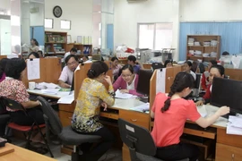 Giải đáp các thắc mắc của người nộp thuế tại Cục thuế Thành phố Hồ Chí Minh. (Ảnh: Hoàng Hùng/TTXVN)