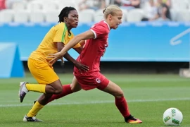 Cầu thủ Rebecca Quinn (phải) của Canada tranh bóng với cầu thủ Zimbabwe trong trận đấu. (Nguồn: AFP/TTXVN)