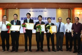Thứ trưởng Bộ Giáo dục và Đào tạo Nguyễn Vinh Hiển trao Bằng khen của Bộ trưởng Bộ GD&ĐT cho các em trong đội tuyển Tin học quốc tế 2015. (Ảnh minh họa: Quý Trung/TTXVN)