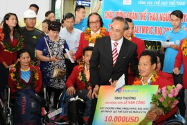 Đại diện các đơn vị, doanh nghiệp trao phần thưởng cho vận động viên Lê Văn Công-HCV Paralympic Rio 2016 và phá kỷ lục thế giới môn cử tạ. (Ảnh: An Hiếu/TTXVN)