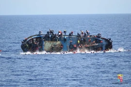 Người di cư nhảy khỏi con tàu bị lật ở ngoài khơi bờ biển Libya, gần Sicily (Italy) ngày 25/5. (Nguồn: EPA/TTXVN)