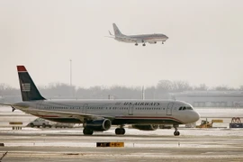 Máy bay của American Airlines bay qua máy bay của US Airways tại sân bay O'Hare ở Chicago, Illinois. (Nguồn: AFP/TTXVN)