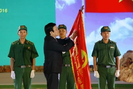 Chủ tịch nước Trương Tấn Sang trao Huân chương Độc lập hạng B lên lá cờ truyền thống của Lực lượng Thanh niên Xung phong TP.Hồ Chí Minh. (Ảnh: Thanh Vũ/TTXVN)