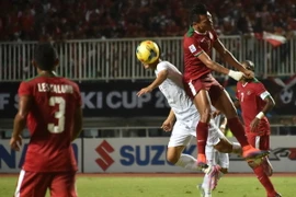 Pha tranh bóng quyết liệt giữa cầu thủ hai đội tuyển Việt Nam và Indonesia trong trận đấu bán kết lượt đi. (Nguồn: AFP/TTXVN)