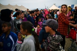 Người tị nạn và di cư xếp hàng đợi nhận khẩu phần ăn tại trại tị nạn ở Idomeni, biên giới Hy Lạp và Macedonia ngày 5/4. (Nguồn: AFP/TTXVN)