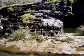 Lực lượng cứu hộ tỉnh Lâm Đồng tìm kiếm du khách Belarus gặp nạn dưới chân thác Pongour. (Ảnh: Đặng Tuấn/TTXVN)