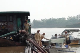 Lực lượng chức năng kiểm tra một tàu hút cát trái phép. Ảnh minh họa. (Nguồn: Thái Hùng/TTXVN)