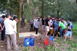 Thi thể em Nguyễn Văn Hướng được đưa lên bờ an táng vào chiều 9/5. (Ảnh: Văn Đạt/TTXVN)