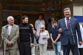 Yuri Soloshenko (trái) và Gennady Afanasyev (thứ 2, trái) tại thủ đô Kiev, Ukraine, sau khi được Nga trả tự do. (Nguồn: EPA/TTXVN)