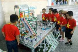 Phụ huynh học sinh và các em nhỏ thích thú xem các đồ dùng, đồ chơi, mô hình từ vỏ hộp sữa đã qua sử dụng tại Ngày hội SHĐ Đà Nẵng.