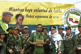 Cựu thủ lĩnh FARC Ivan Marquez (giữa) và Jesus Santrich (thứ 4, phải) tuyên bố bắt đầu một cuộc đấu tranh vũ trang mới và rút khỏi thỏa thuận hòa bình ký kết với Chính phủ Colombia năm 2016, tại một địa điểm bí mật. (Ảnh: AFP/TTXVN)