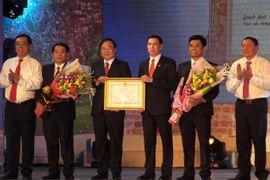 Bí thư Tỉnh ủy Quảng Trị Nguyễn Văn Hùng, thừa ủy quyền Chủ tịch nước, trao Huân chương Lao động hạng Nhất cho Đảng bộ, chính quyền và nhân dân thị xã Quảng Trị. (Ảnh: Trịnh Bang Nhiệm/TTXVN)